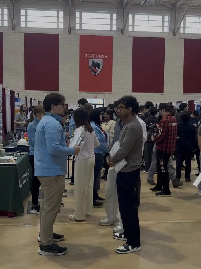 a student speaks with a professional at a CMU career fair