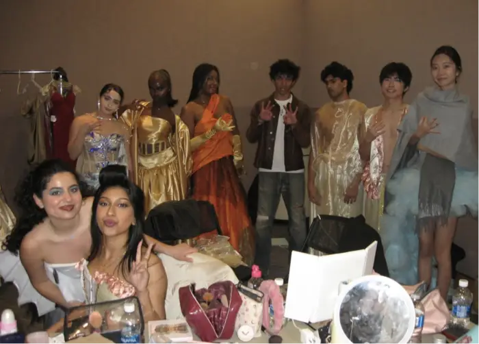 Behind the scenes photo of people getting ready for the fashion show. 