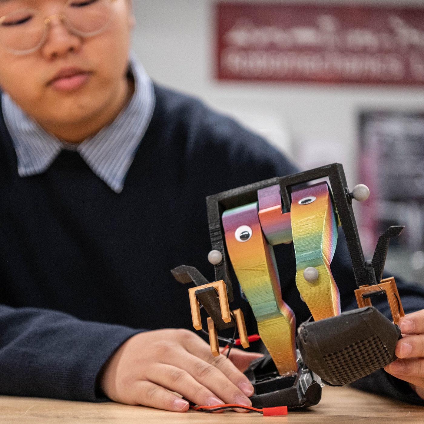 student holding small biped robot
