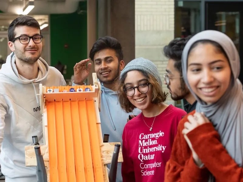 CMU Qatar students working together, using small cars for racing.